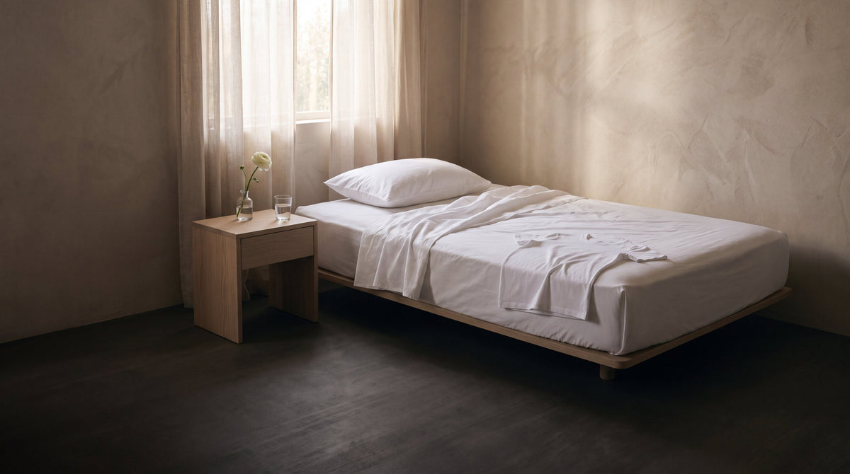 A calm bedroom with crisp white cotton sheets in morning light, sleeping with a new tattoo