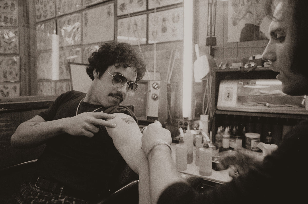 Vintage photograph of a tattoo artist at work in his studio, legendary tattoo artists